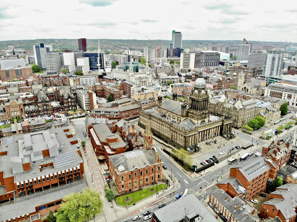 Aerial view of Leeds city centre with Leeds Town Hall and red-brick civic buildings.