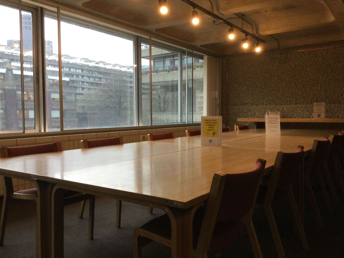An empty meeting room in London with a long wooden table and large windows.