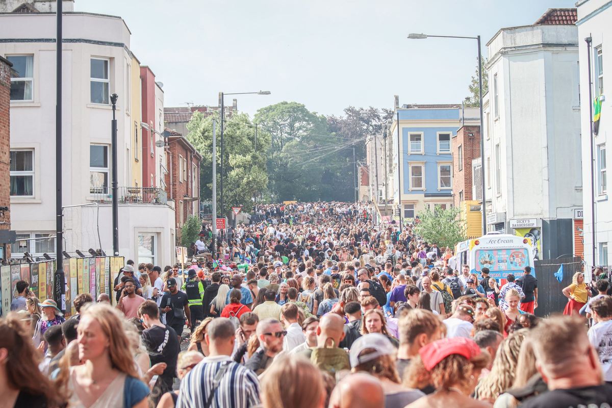A large crowd fills a street in Bristol during an outdoor festival.