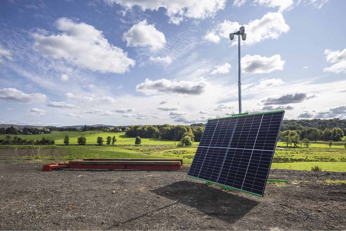 A solar-powered CCTV tower standing on open ground at a UK site.