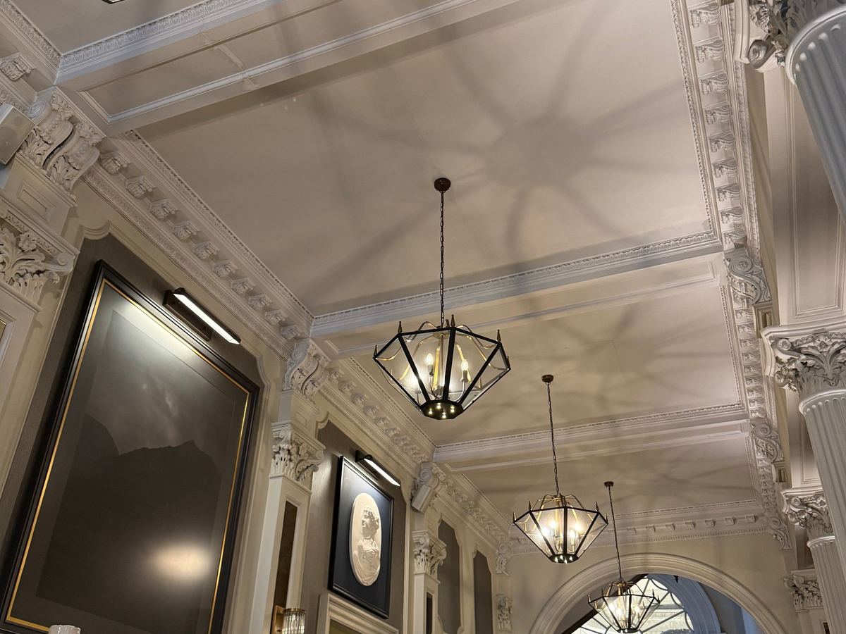 The ornate entrance hall of a historic building in Edinburgh, with chandeliers.