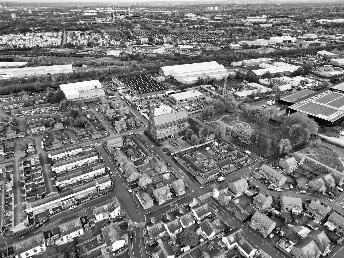An aerial view of an industrial area in Manchester, with warehouses beside terraced streets.